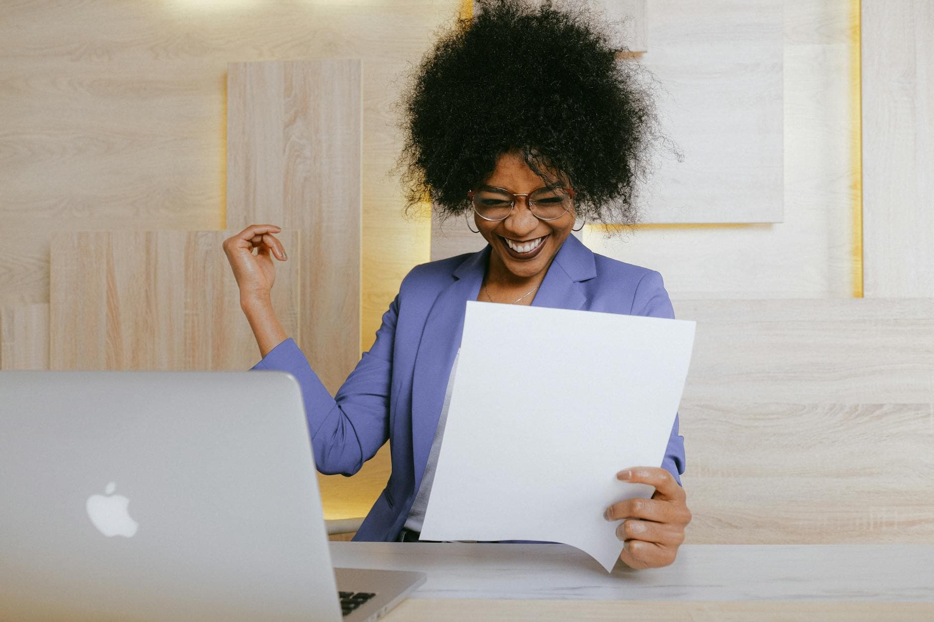 Woman celebrating job search success at work, looking at a document with confidence