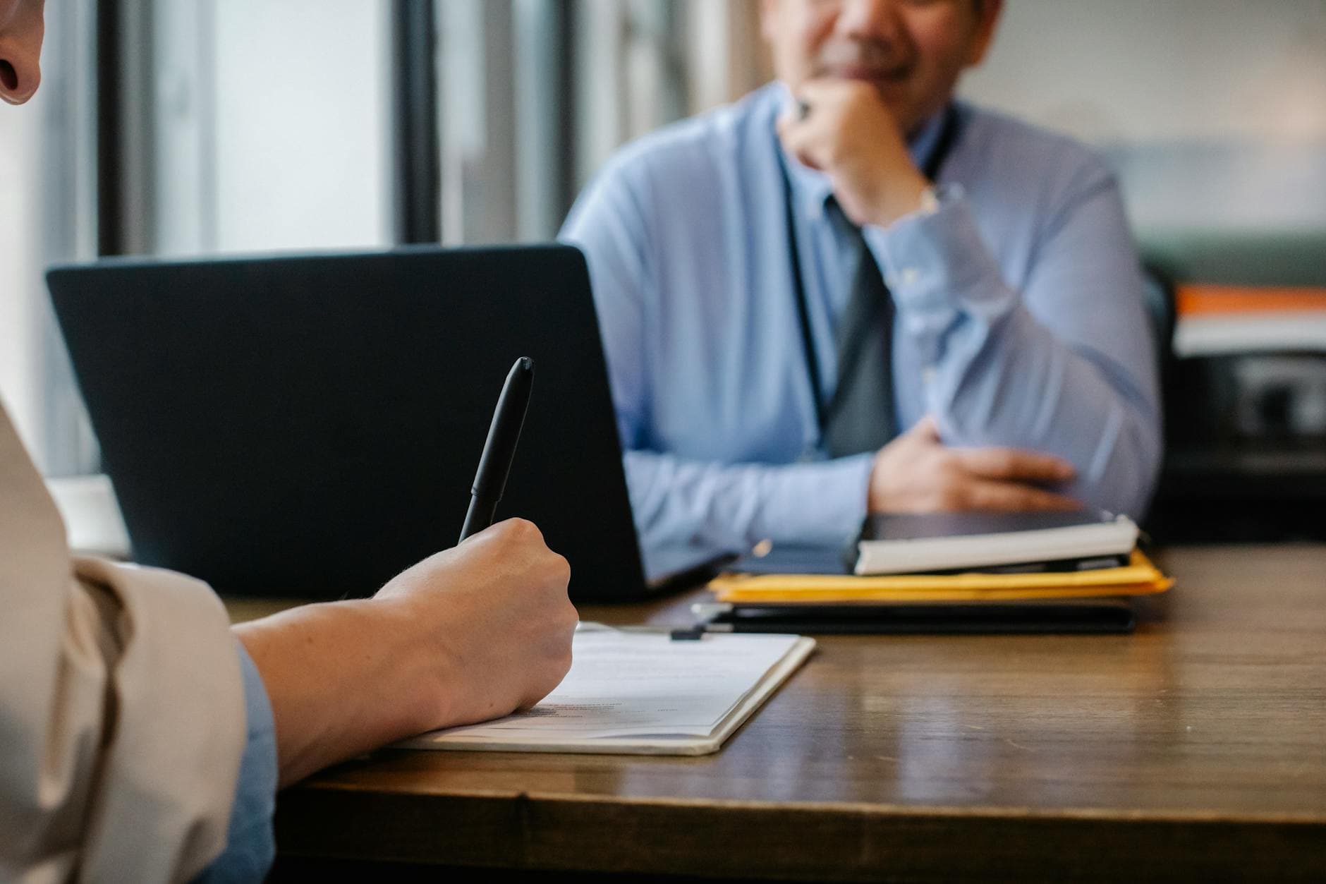Person reviewing resume and job application documents at a desk, showing the manual process of resume screening